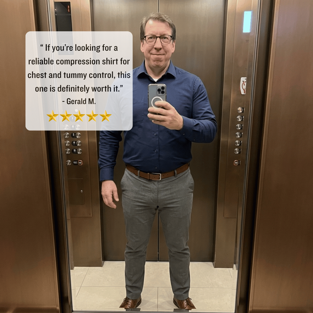 Man taking a mirror selfie in an elevator wearing a blue shirt and gray pants, with a text overlay about compression shirts.